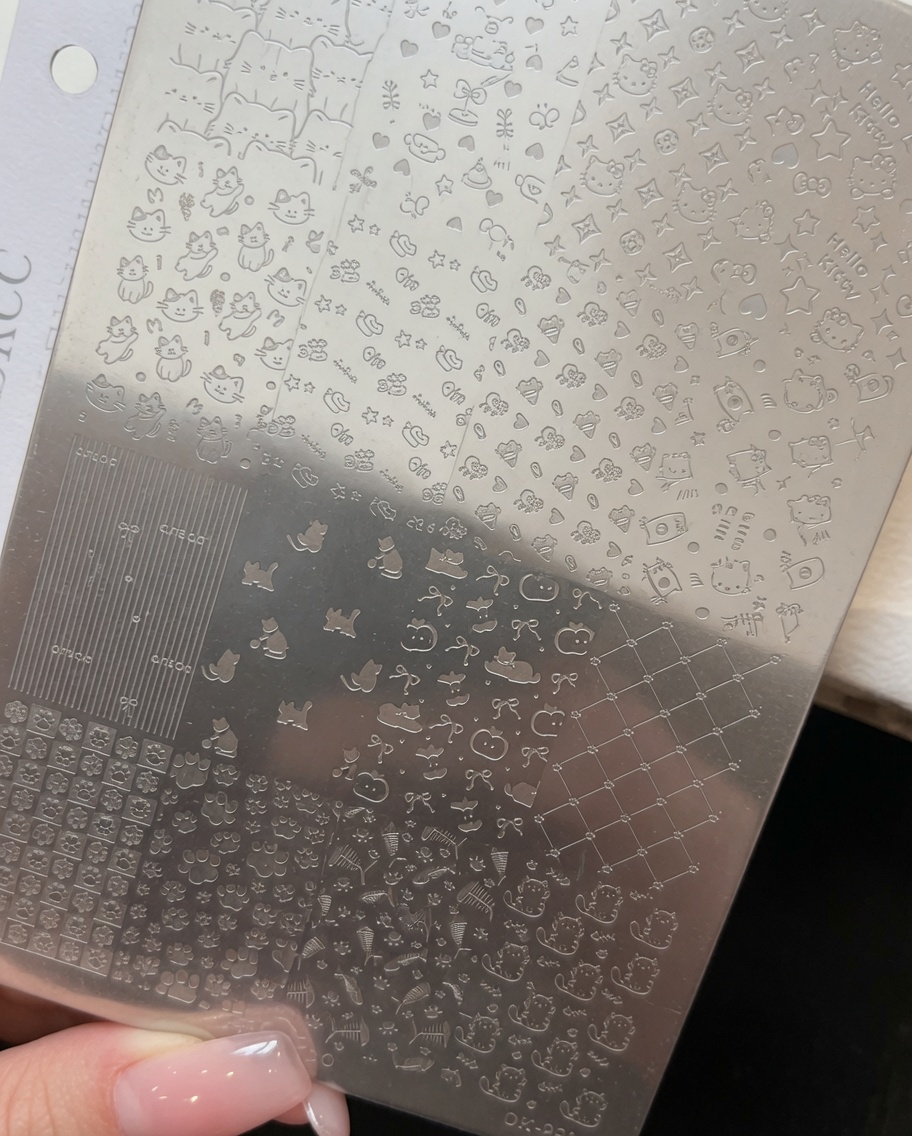 Un sottile strato di smalto gel rosa antico applicato su un design a tema Kitty su una piastra metallica per stamping.