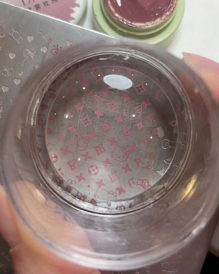 Un timbro trasparente in silicone che mostra chiaramente il motivo di Hello Kitty e del logo appena prelevato.