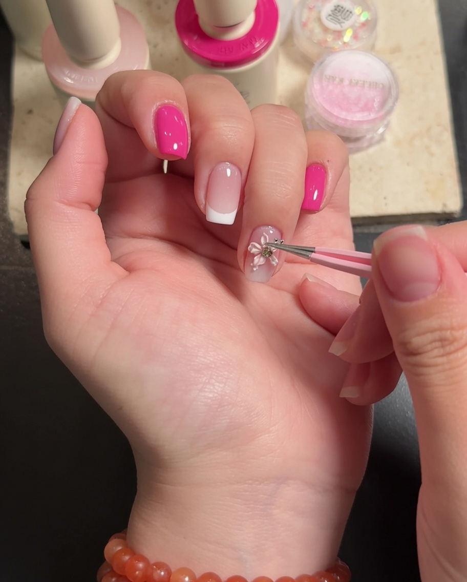 Un pennello applica un top coat trasparente finale attorno ai bordi di una decorazione floreale 3D.