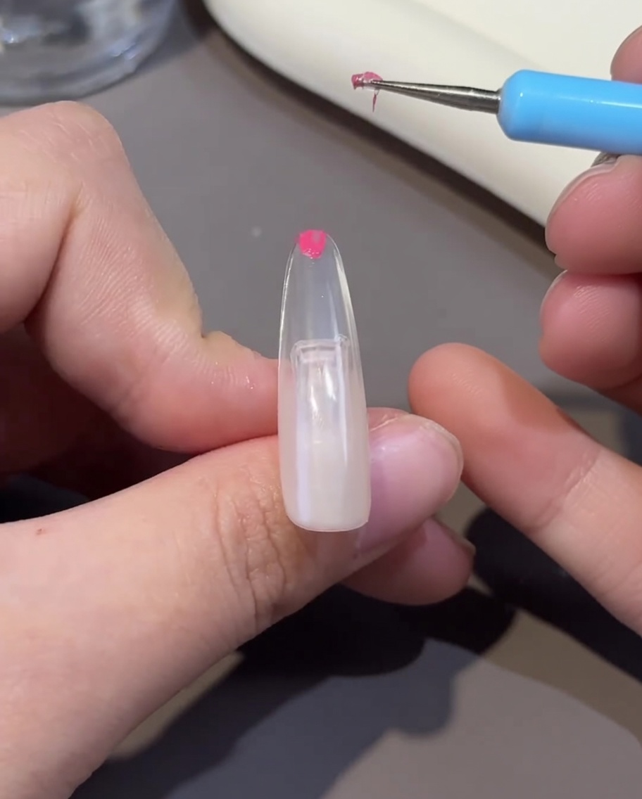 Una tip unghia in fase di polimerizzazione sotto la lampada UV/LED.