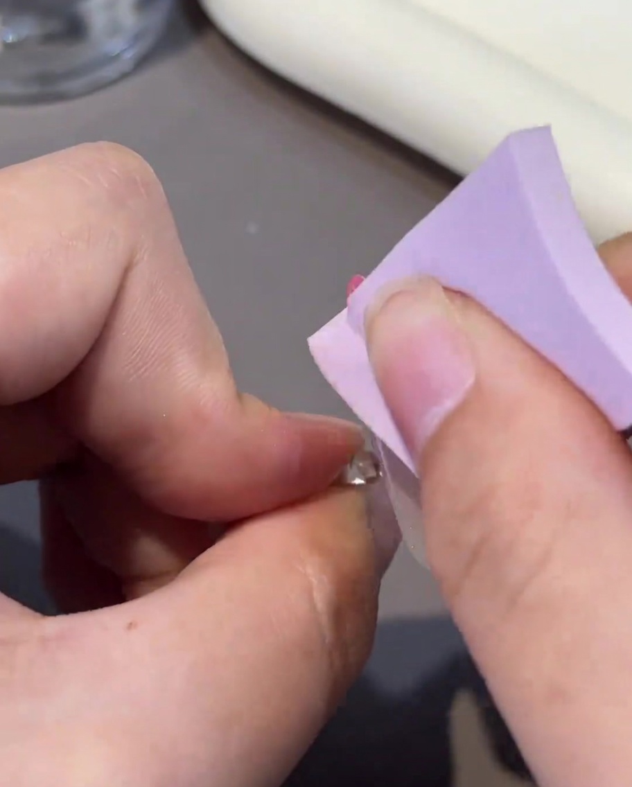 Un pad senza pelucchi pulisce la superficie di ununghia gel polimerizzata.