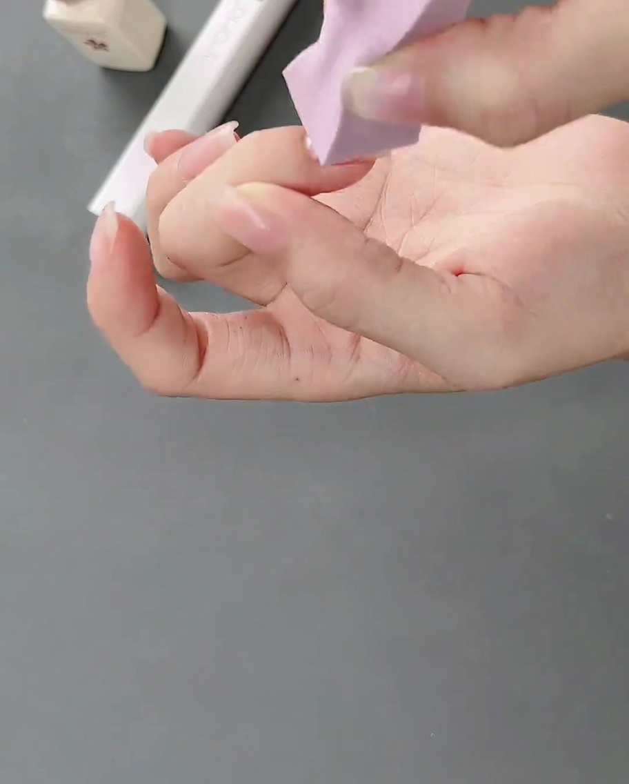 Una spugnetta da trucco applica del gel bianco su ununghia naturale per creare un morbido effetto sfumato.