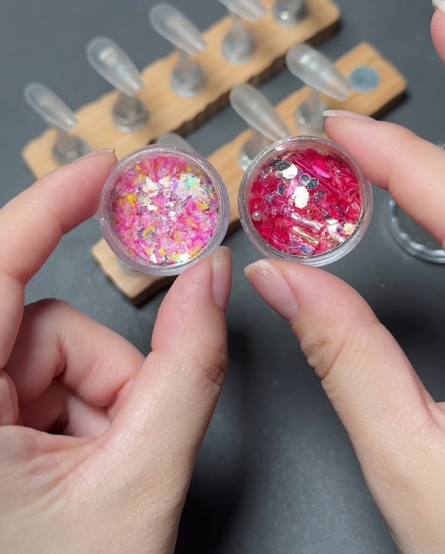 Un pennello che posiziona paillettes vivaci e multicolori sulla zona della punta di ununghia press-on.