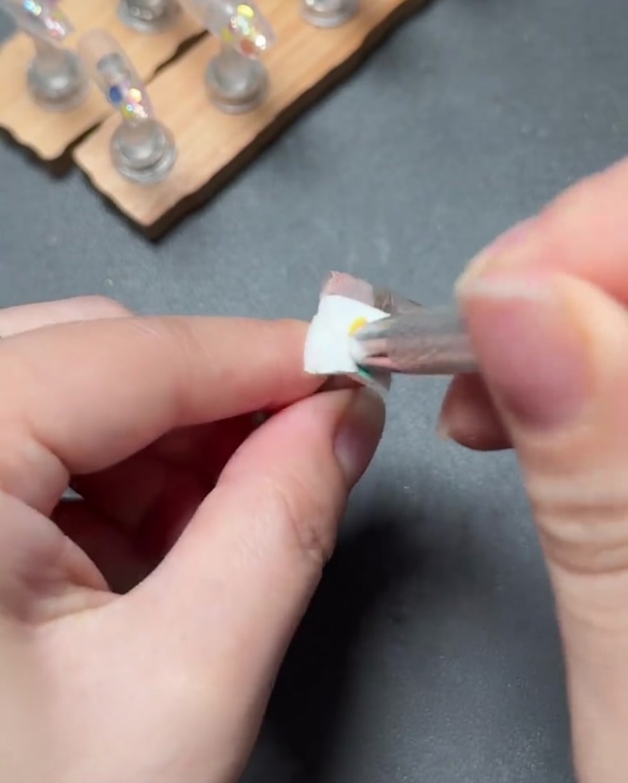 Un piccolo pennello che picchietta gel rosa chiaro per creare una sfumatura uniforme dalla cuticola verso il basso.