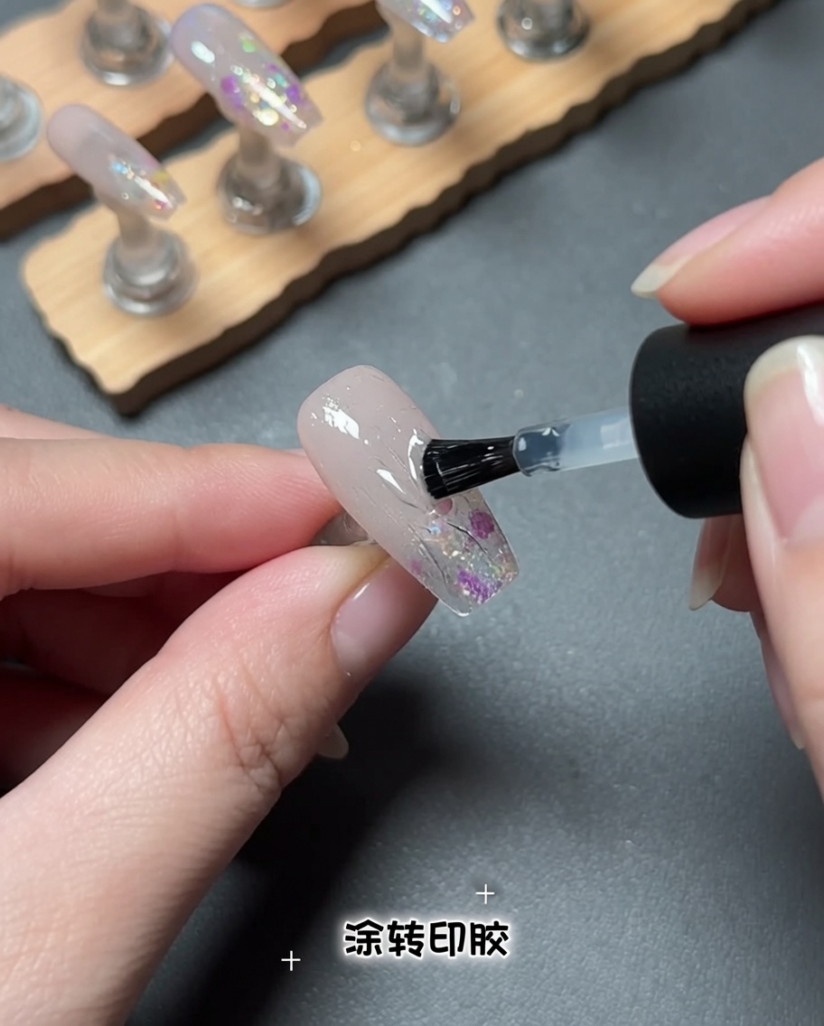 Un pennello che applica un prodotto gel trasparente sulla superficie di ununghia.