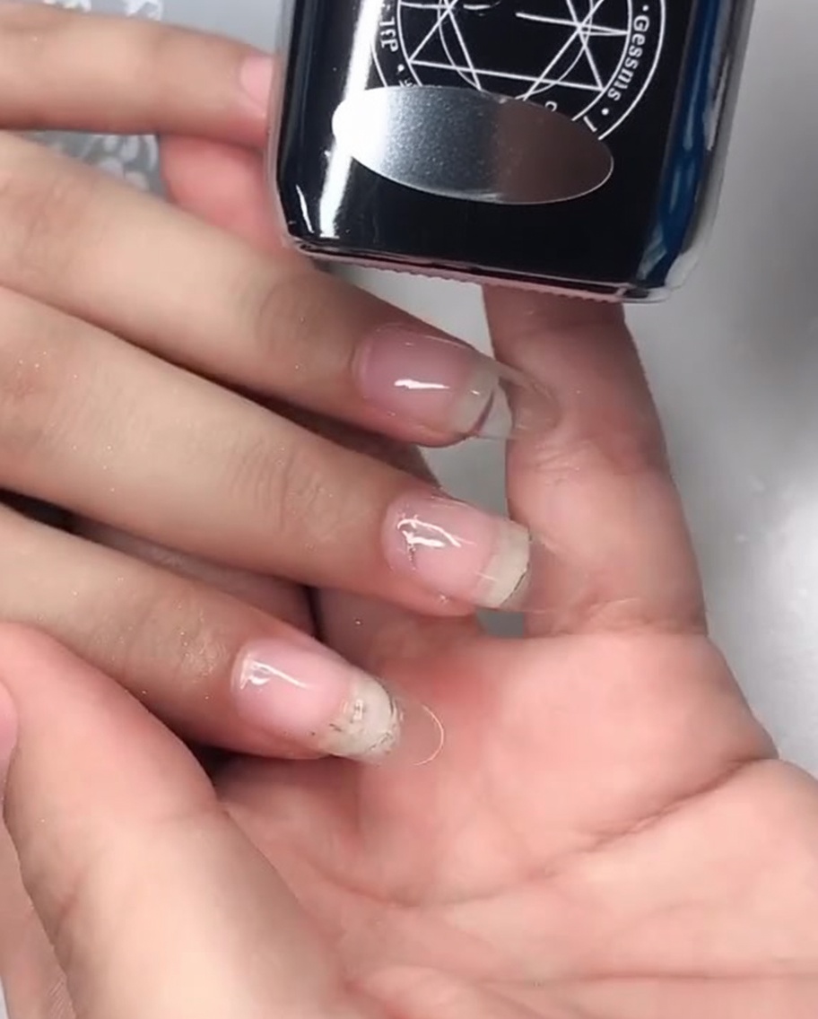 Primo piano che mostra lapplicazione di un gel top coat effetto specchio sulla superficie dellunghia.