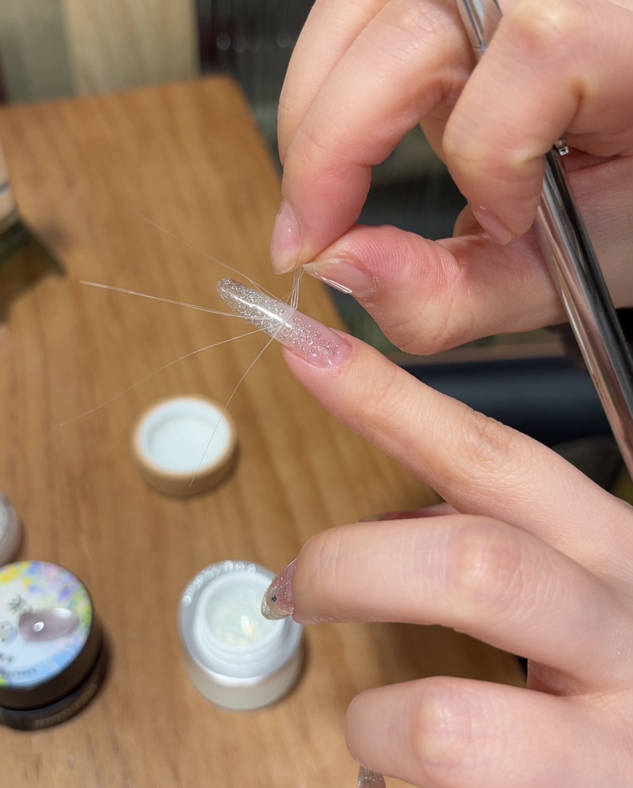 Delle pinzette rimuovono un adesivo guida French dallunghia, lasciando unarea della punta definita.