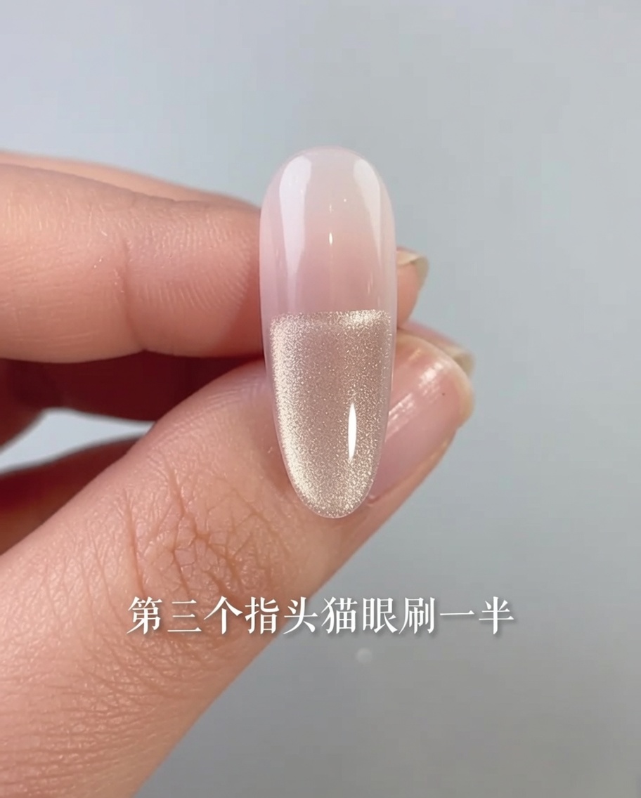 Primo piano di ununghia con smalto gel cat-eye applicato solo sulla metà inferiore del letto ungueale.