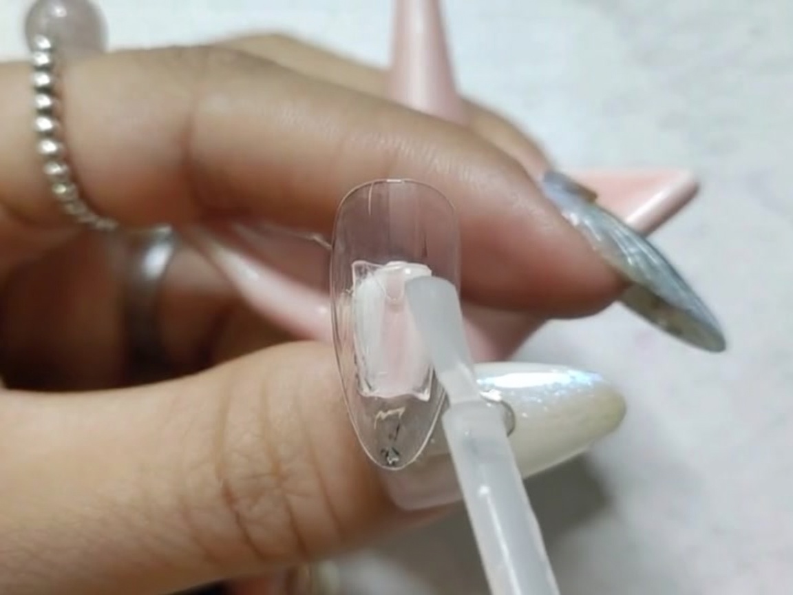 Una tip per unghie allinterno di una piccola lampada UV/LED per la polimerizzazione.
