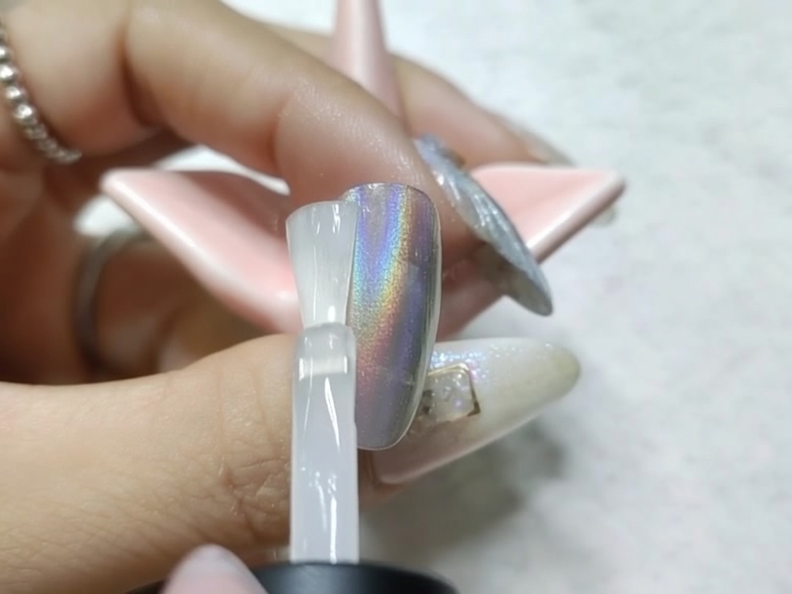 Ununghia cromata sotto la lampada UV/LED dopo lapplicazione del top coat opaco.