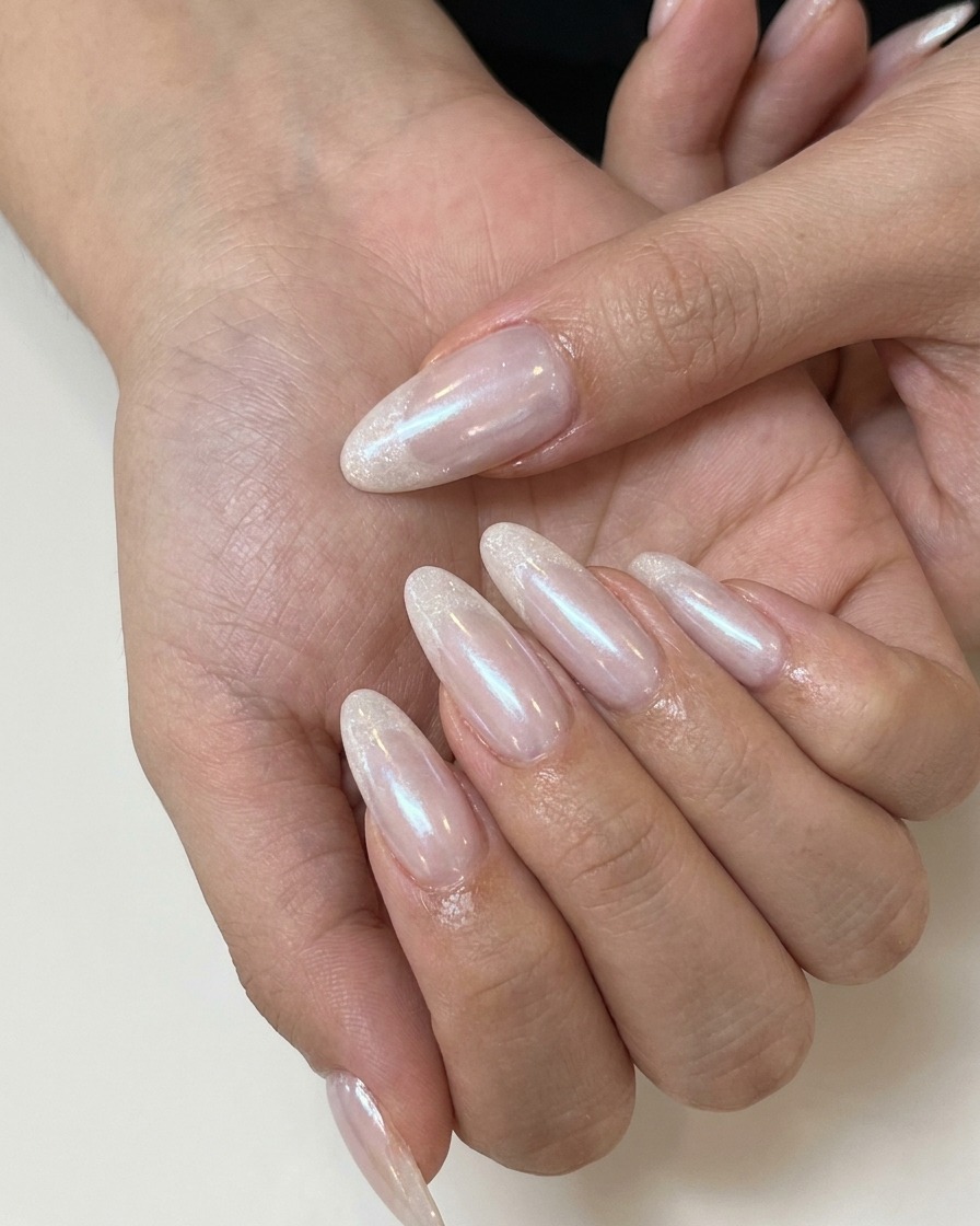 Unonicotecnica che applica un top coat opaco su ununghia gel nude rosata.