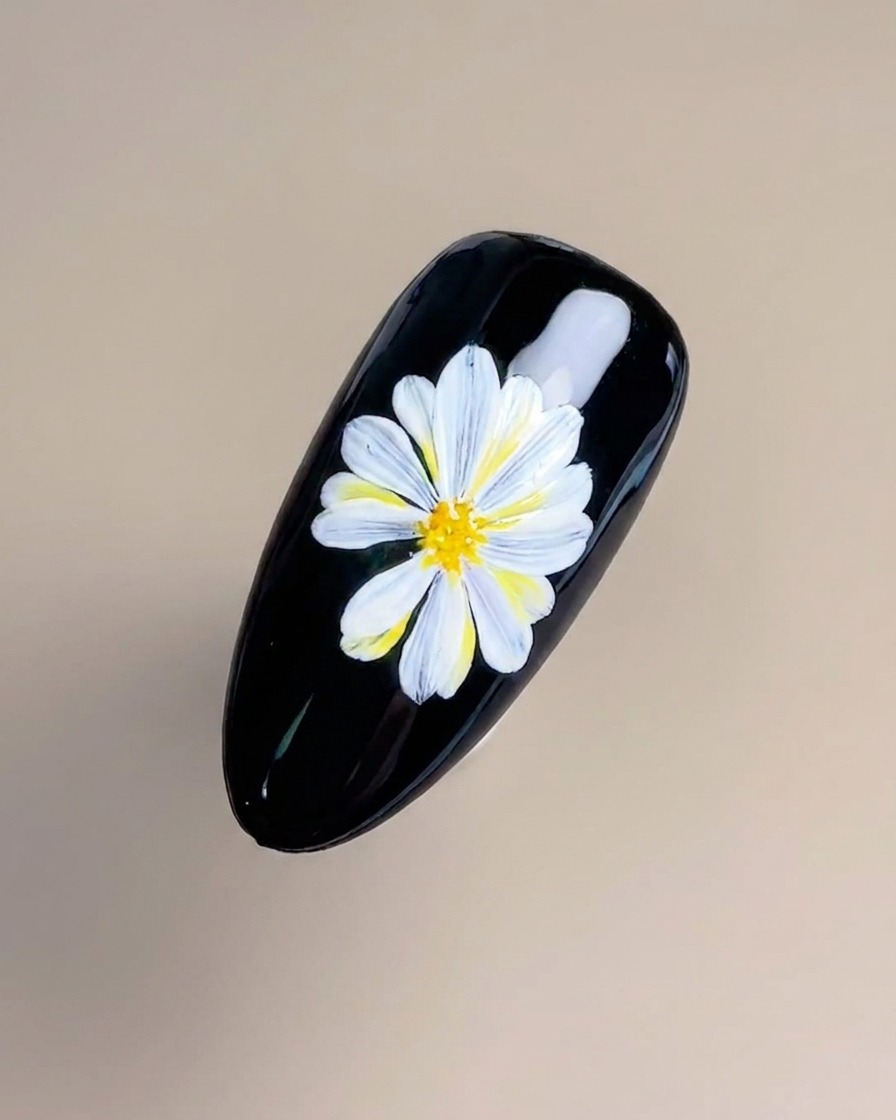 Un pennello liner a punta fine che applica delicatamente sottili linee gialle e arancioni al centro del fiore.