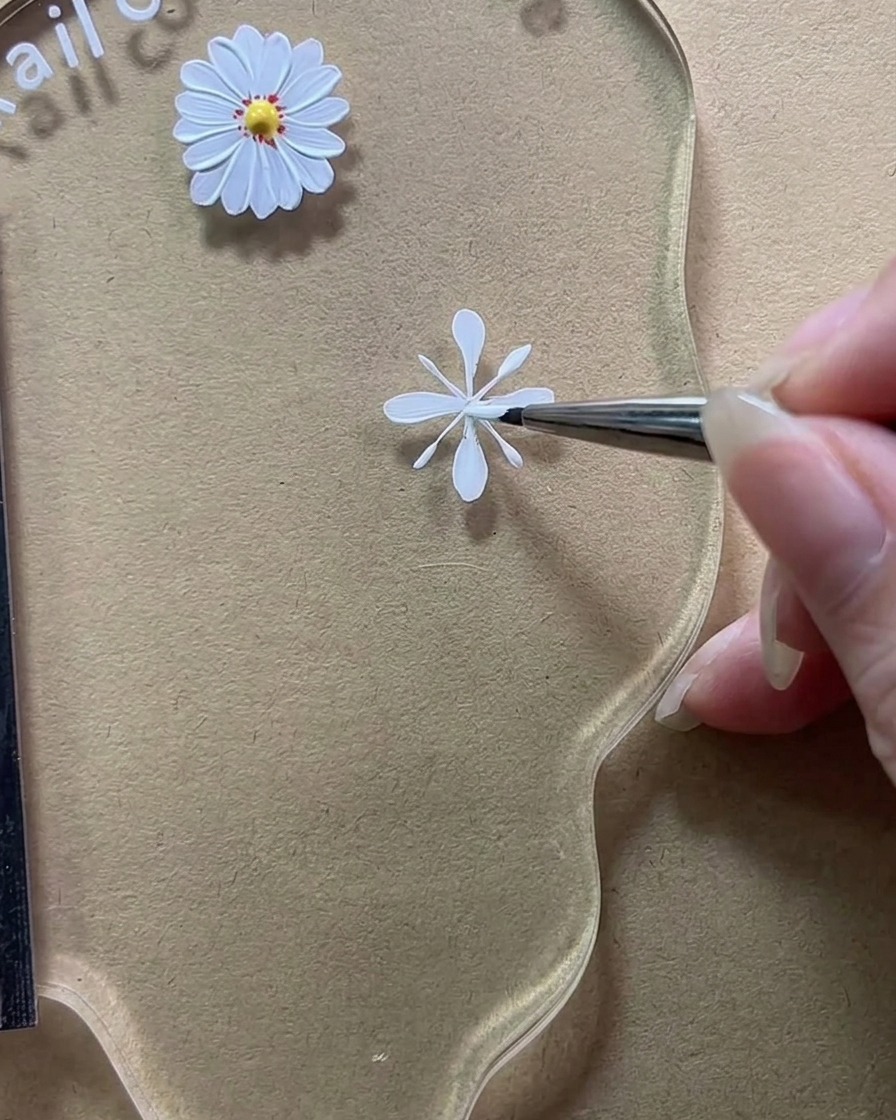 Dettaglio di un pennello che riempie le linee guida verticali per creare petali bianchi pieni e opachi.