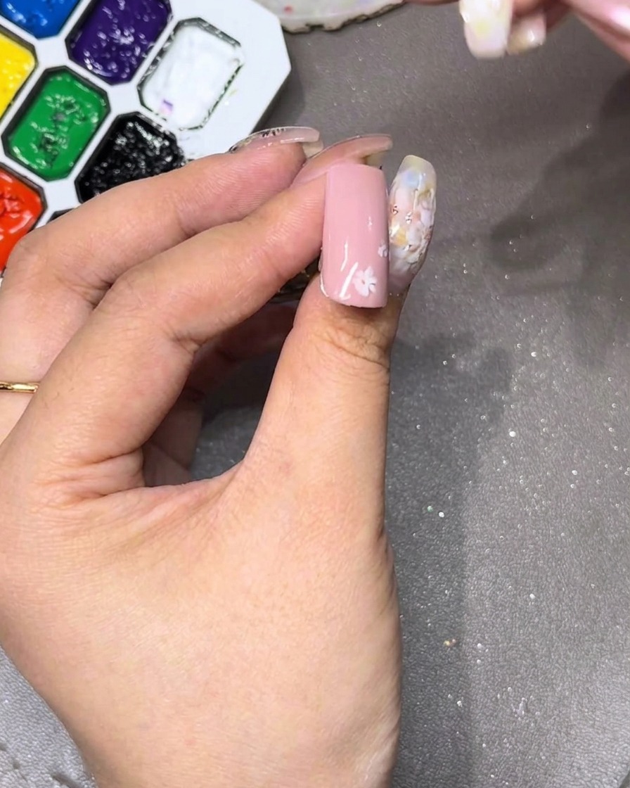 Un primo piano dellunghia che mostra il petalo bianco iniziale disegnato nella parte superiore.