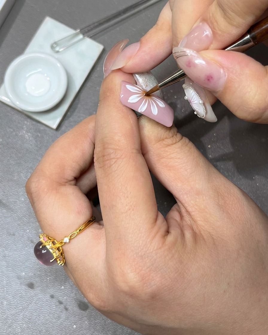 Un pennello che applica un secondo strato di petali in gel bianco sopra lo strato iniziale del fiore per aggiungere profondità.