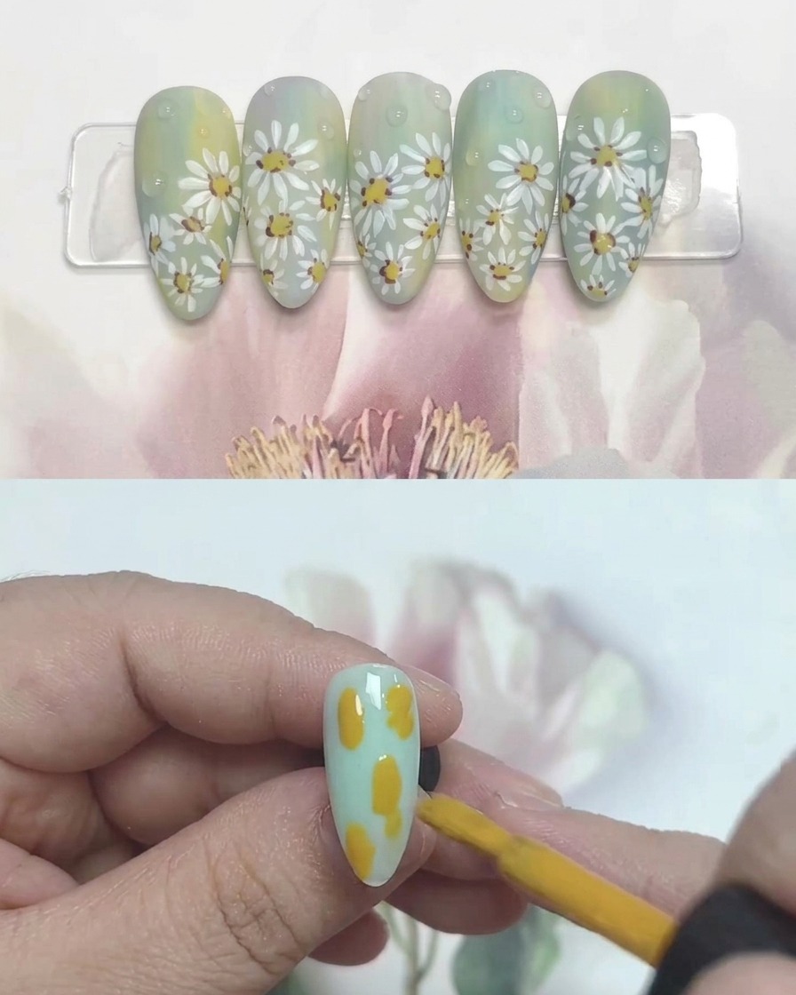 Un pennello per unghie che applica macchie di gel giallo, blu e bianco su una tip trasparente.