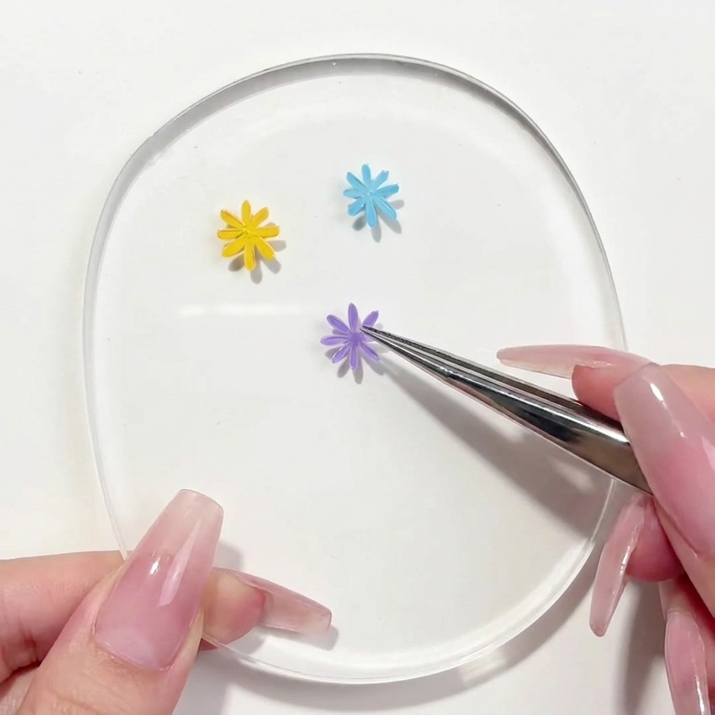 Un pennello liner che applica un secondo petalo viola al design della margherita sulla tavolozza.