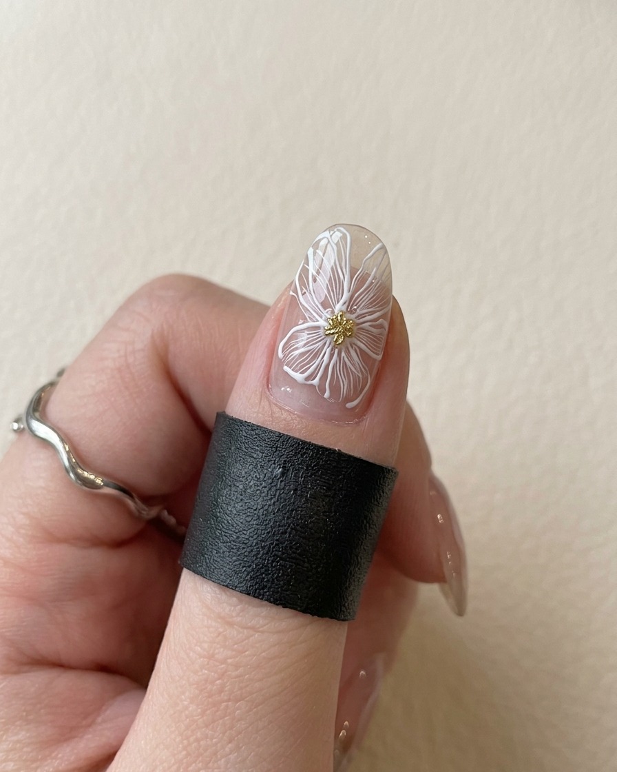 Ununghia con un fiore bianco e centro oro posta sotto una lampada UV viola per polimerizzare.
