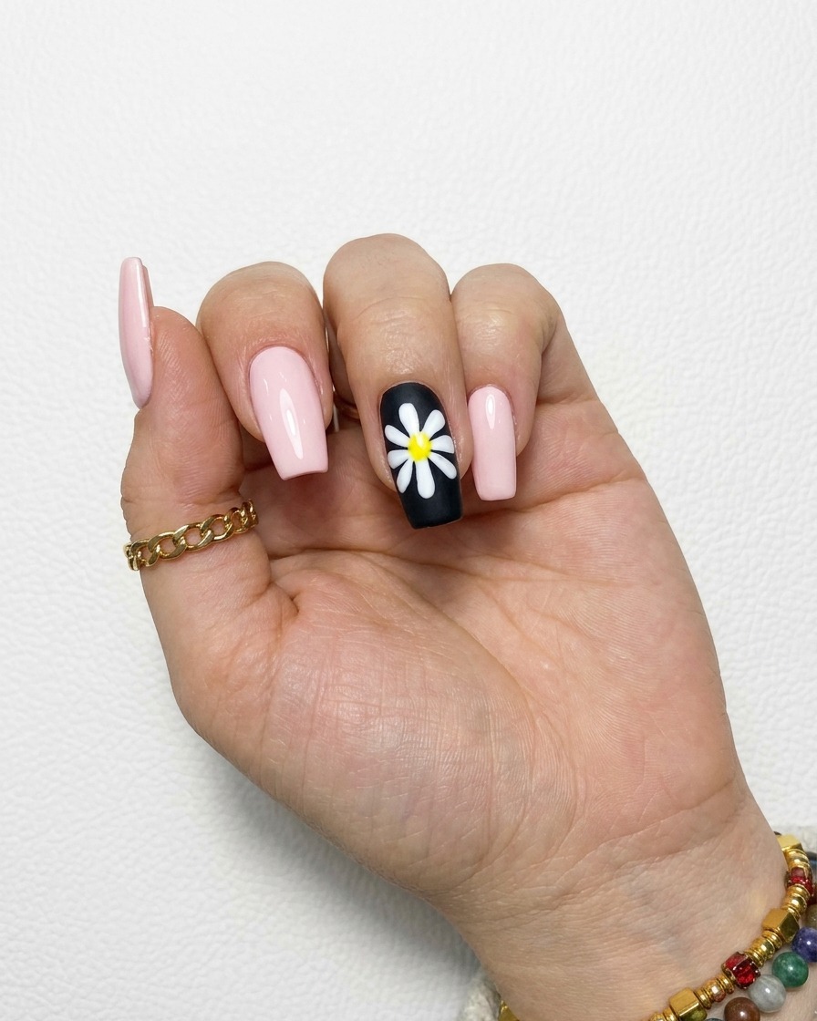 Un design a margherita bianca completato su ununghia nera con petali pieni e opachi.