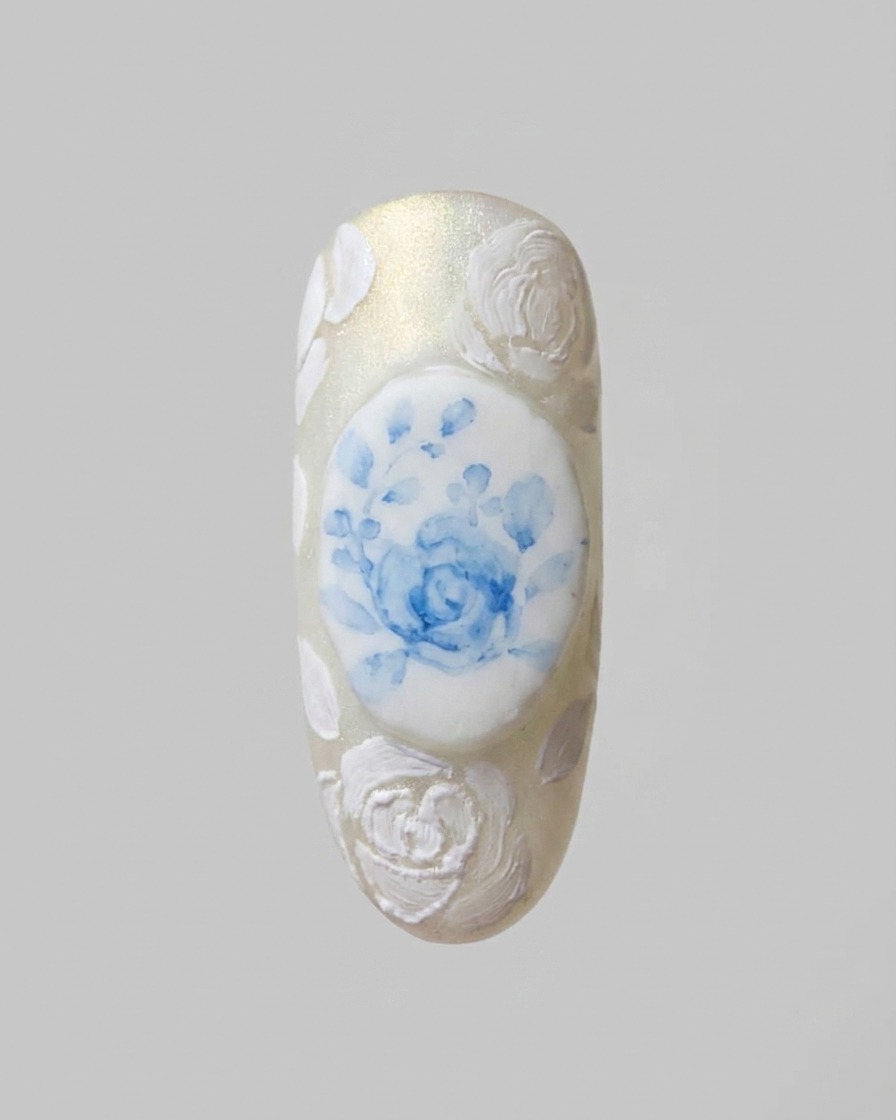 Un pennello di precisione aggiunge sottili motivi in pizzo bianco che collegano i design delle rose 3D.