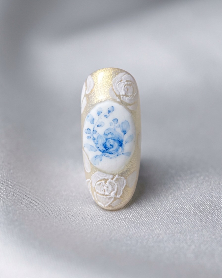 Un design dellunghia finito con una rosa blu centrale circondata da rose bianche 3D e lavori in pizzo.