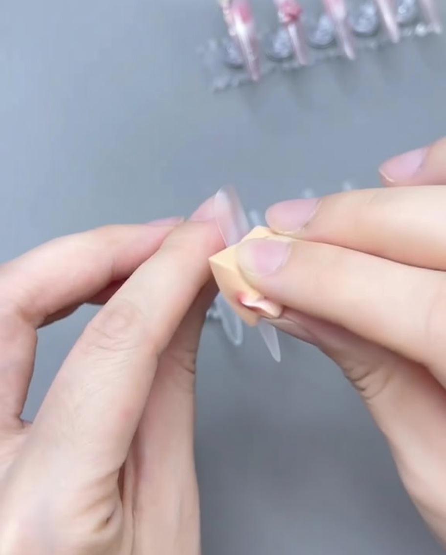 Un pennello sfuma il gel rosa sulla tip per creare un gradiente ombré.