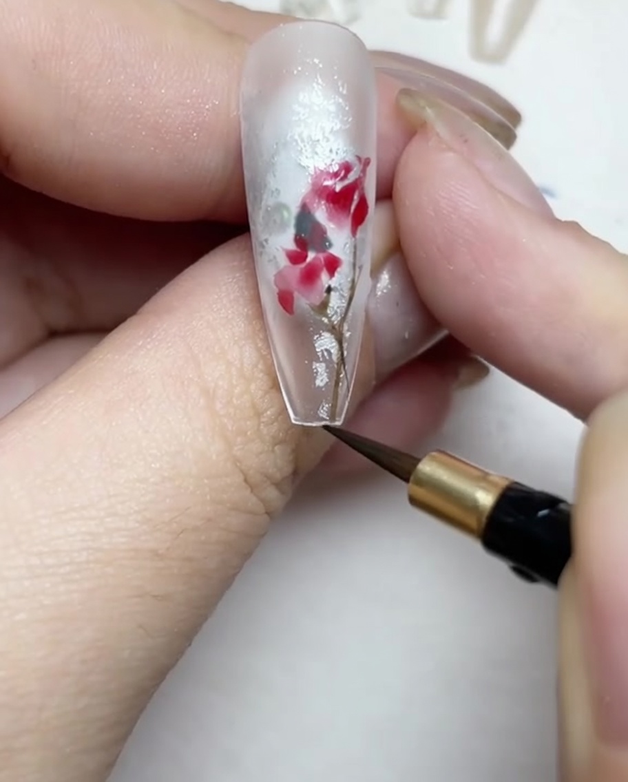 Disegno di steli e foglie sottili marroni e verdi attorno al design della rosa.