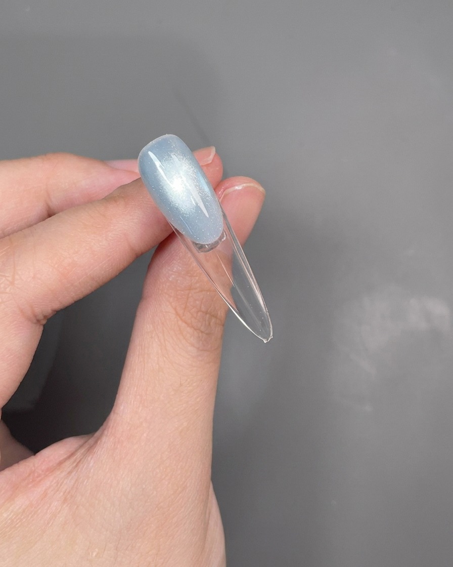 Dettaglio di uno strumento dotting che crea una sottile linea argentata lungo la linea del sorriso French.