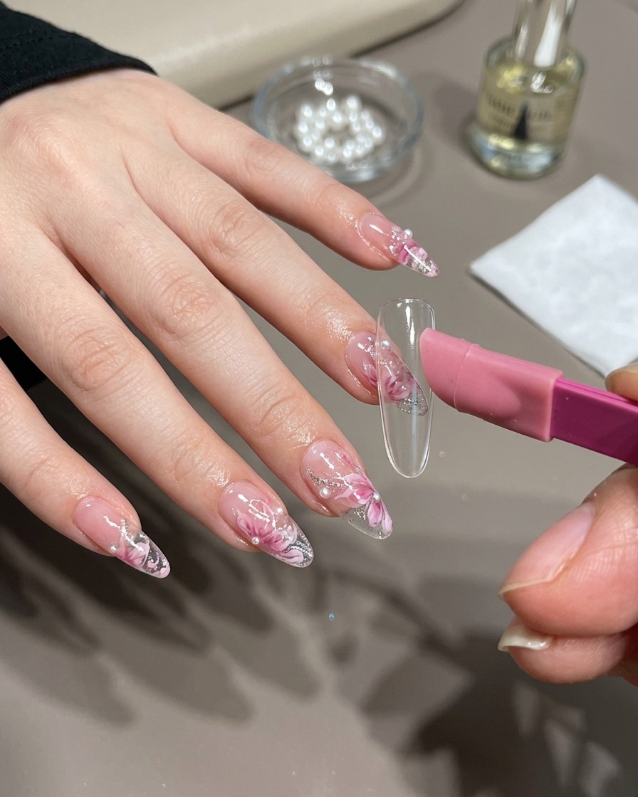 Un pennello da nail art che applica gel magnetico dorato su una tip.