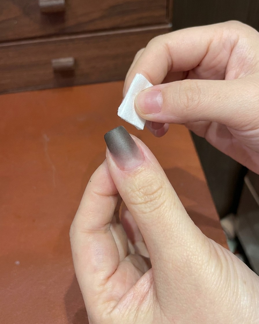 Una mano posiziona un dito sotto una piccola lampada UV/LED portatile.