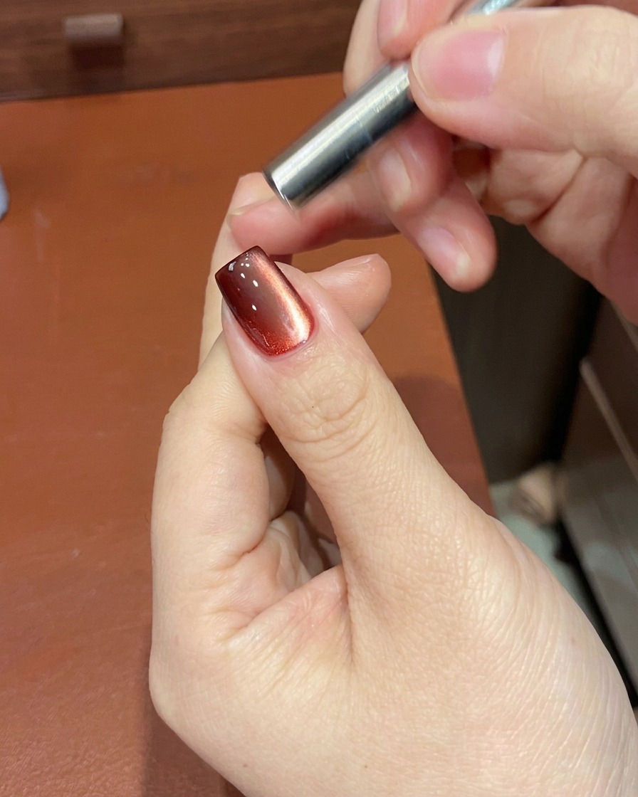 Uno strumento magnetico posizionato vicino allunghia per manipolare le particelle glitterate nel gel rosso.