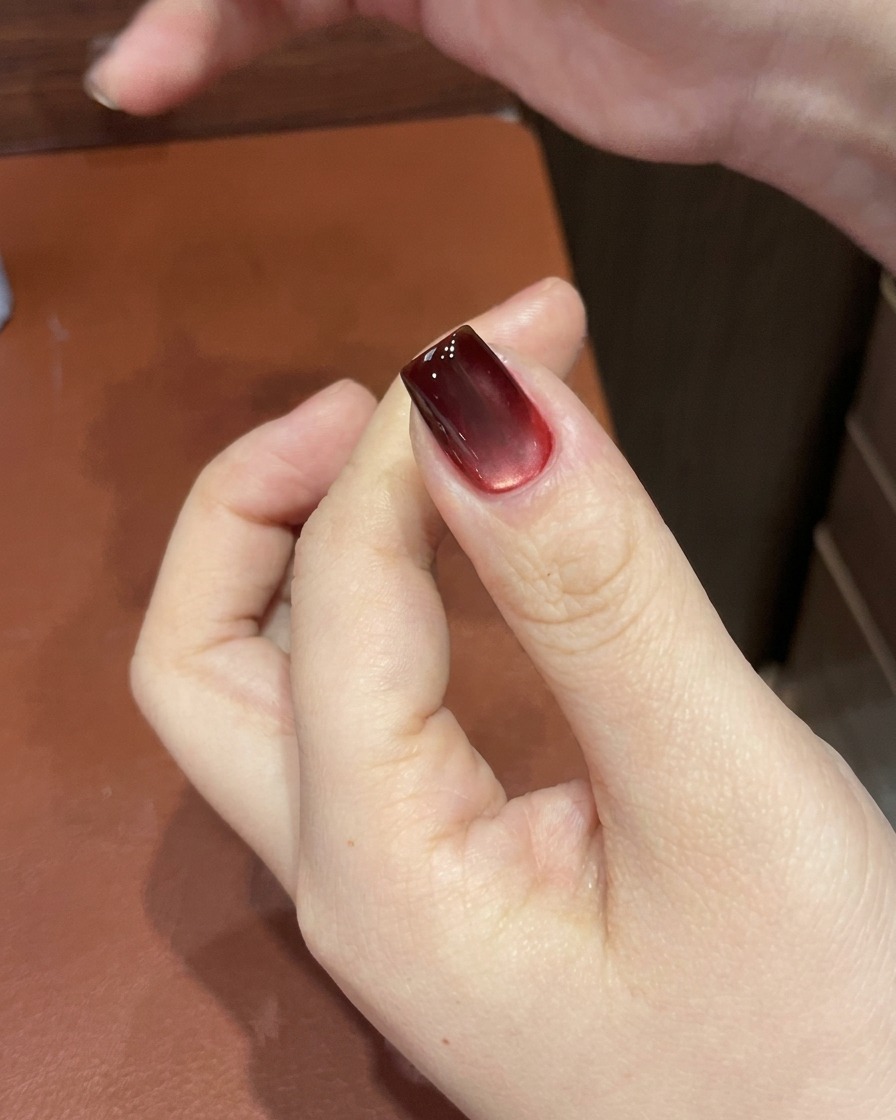 Ununghia gel cat-eye rossa in fase di polimerizzazione allinterno di una lampada UV/LED.