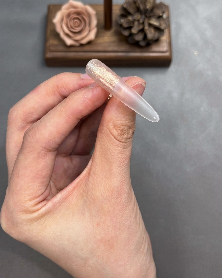 Un pennello sfuma i bordi del gel cat-eye applicato sulla tip per creare una transizione morbida.