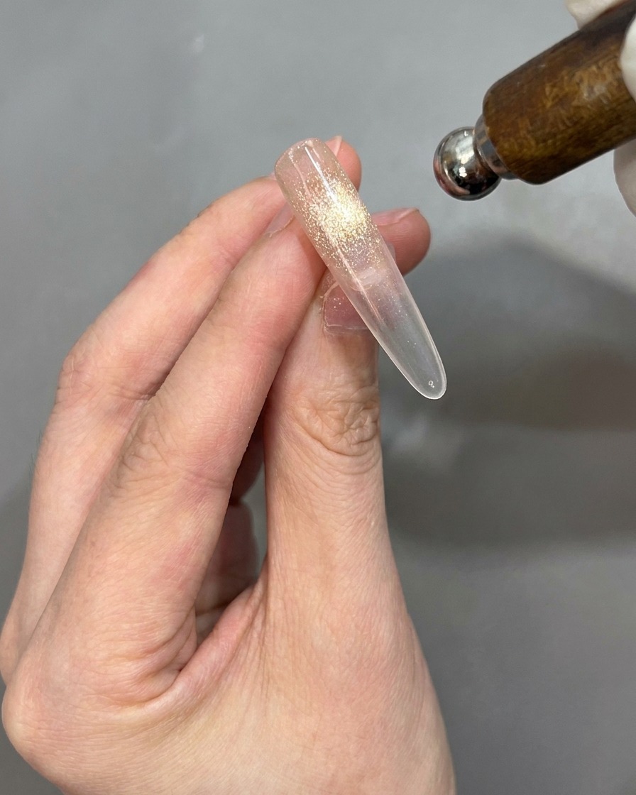 Un magnete viene avvicinato alla tip per attivare leffetto cat-eye, con la tip posizionata per essere girata.