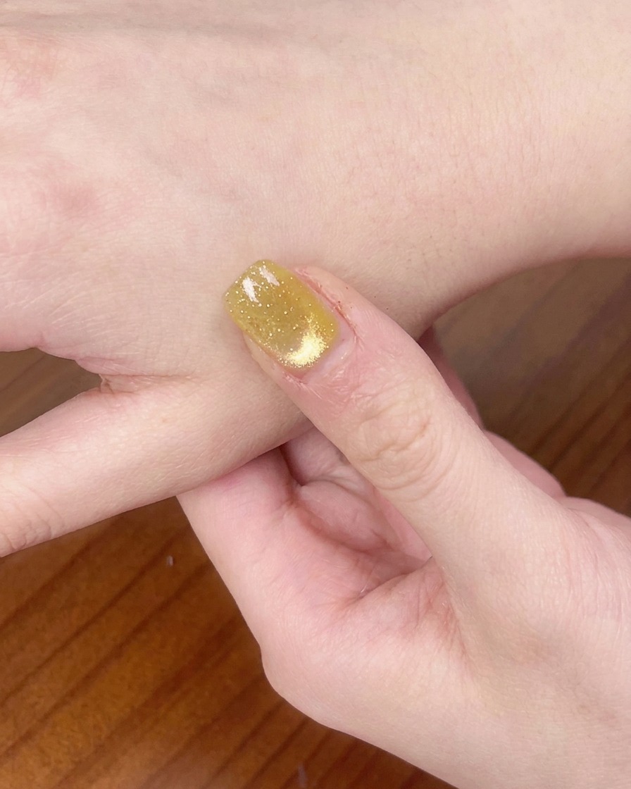 Una mano che riposa allinterno di una lampada per unghie UV/LED mentre polimerizza lo smalto gel.