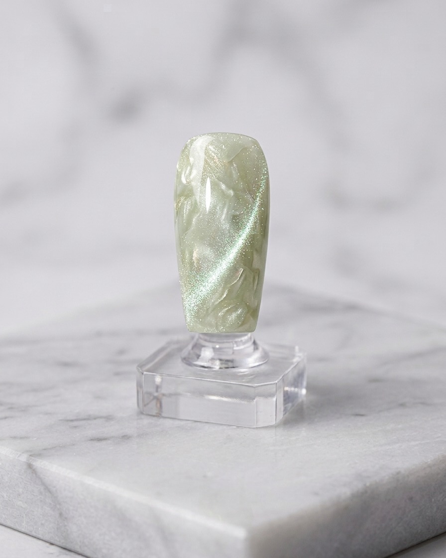 Un pennello che applica un secondo strato di gel cat-eye sulla base polimerizzata.