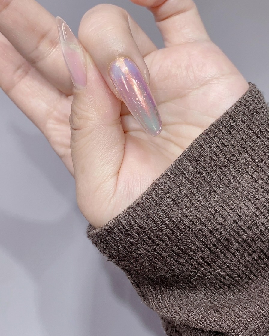 Le unghie sotto una piccola lampada UV/LED rosa dopo lapplicazione del gel glitter argento.
