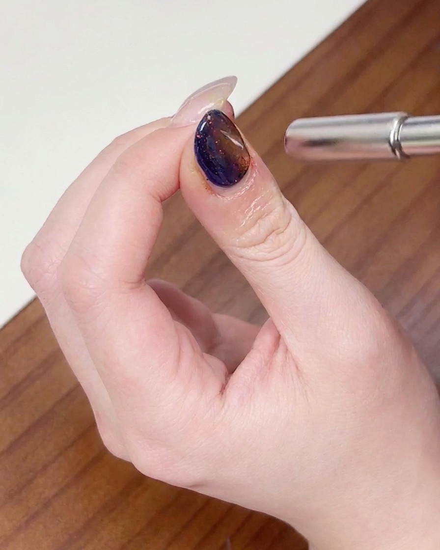 Un magnete che viene mosso con un movimento circolare attorno alla punta dellunghia per modellare il riflesso cat eye.