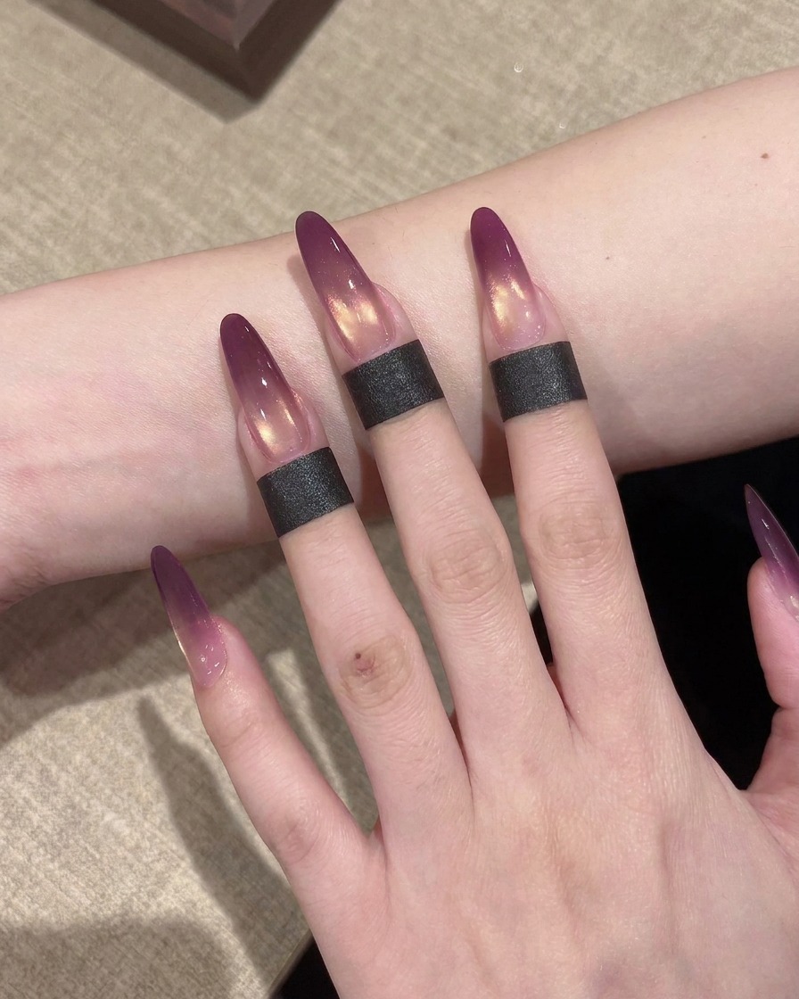 Primo piano di una piccola spugnetta utilizzata per tamponare e sfumare il gel viola su unestensione per creare un effetto ombré.