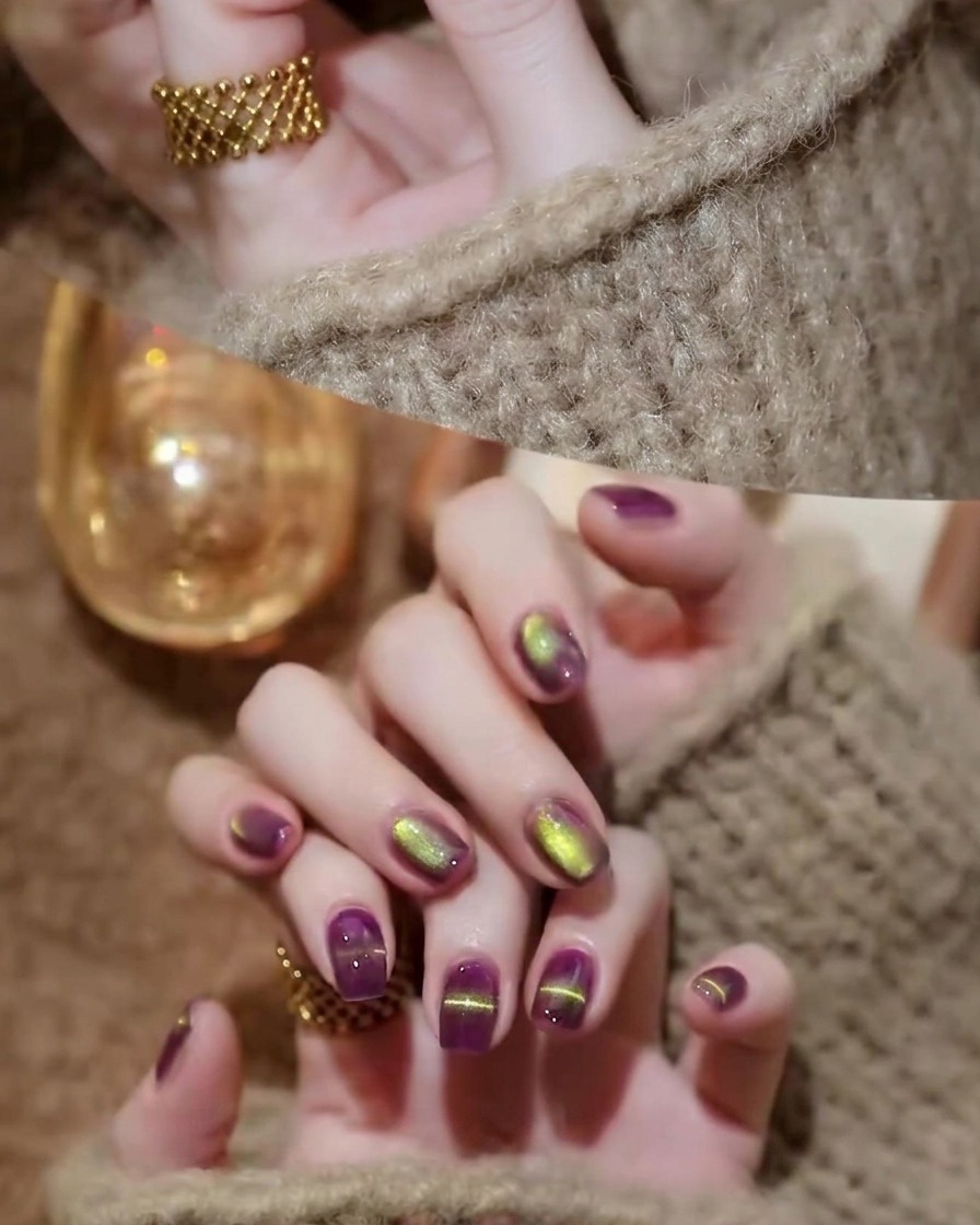 Un pennello per unghie che applica un top coat trasparente e lucido sulle unghie cat-eye viola e oro polimerizzate.
