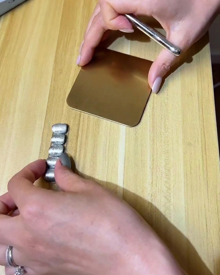 Un pennellino di precisione (liner) disegna una piccola nuvola con gel trasparente su ununghia opaca.