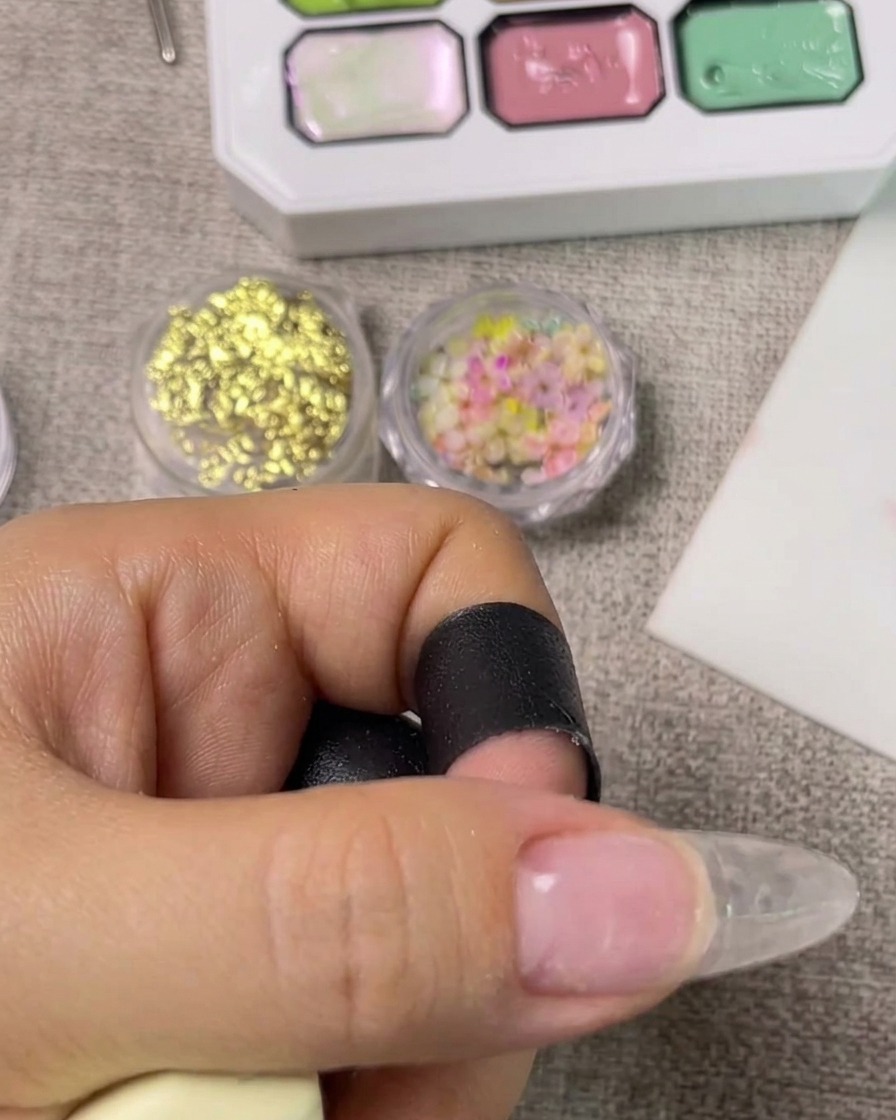 Una mano inserita allinterno di una lampada UV accesa per polimerizzare la base coat.