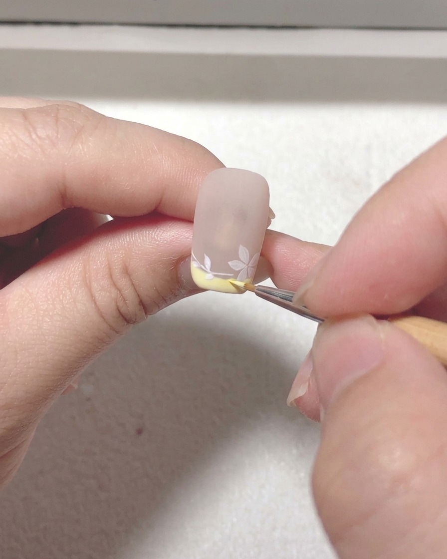 Primo piano di un pennello liner che aggiunge tocchi finali e definisce le linee del design.