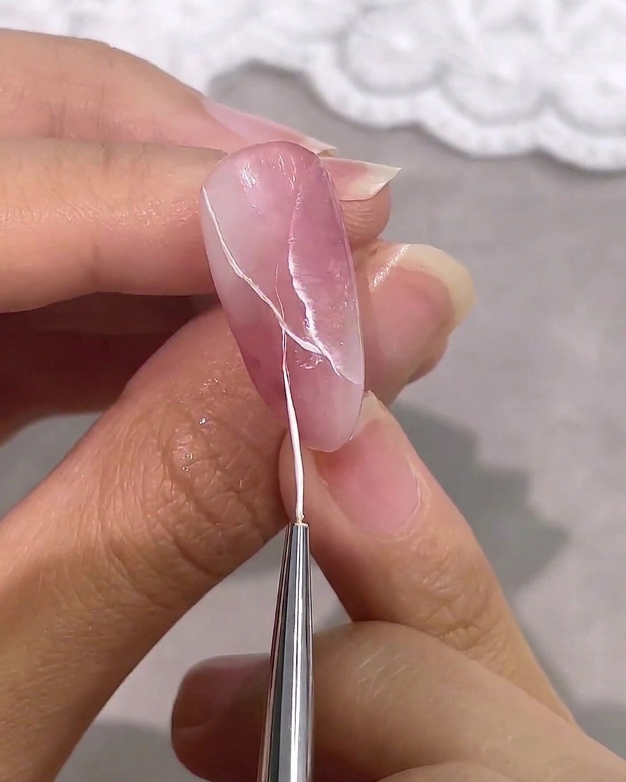 Un pennello fine aggiunge venature bianche sottili e nette a un design effetto marmo rosa e bianco.