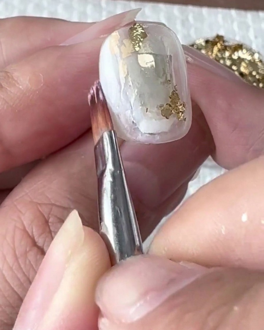 Un pennello fine che sfuma delicatamente il gel bianco nel blooming liquid.