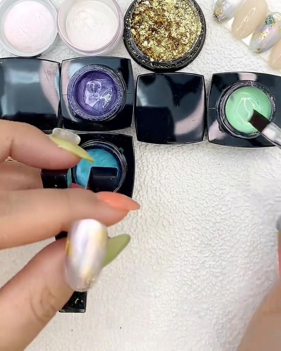 Applicazione di gel verde brillante vicino alle macchie blu con un pennello piatto.