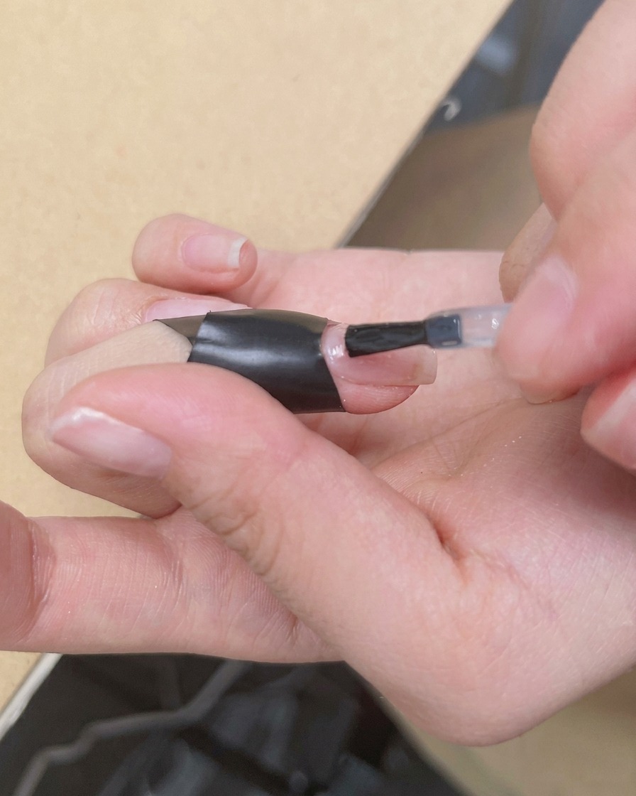 Un pennello applica uno strato trasparente e lucido di blooming gel sopra la base nude.
