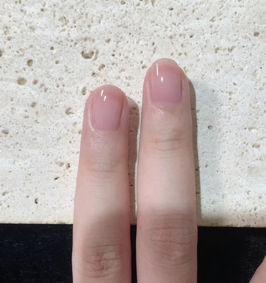 Un pennello per unghie che rifinisce con cura i bordi e la punta di ununghia dipinta di rosa