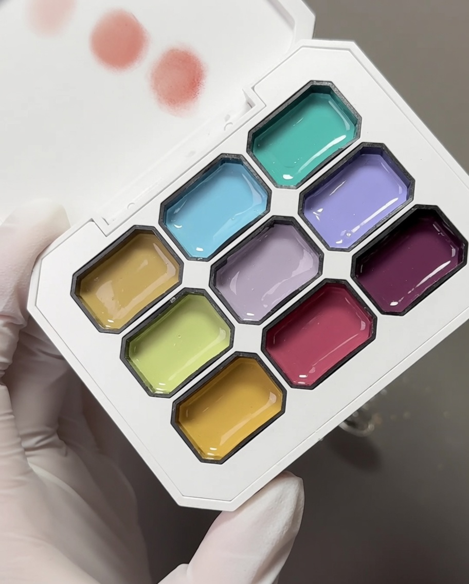 Tavolozza con vari gel pastello e una spugnetta per makeup pronta per prelevare i pigmenti.