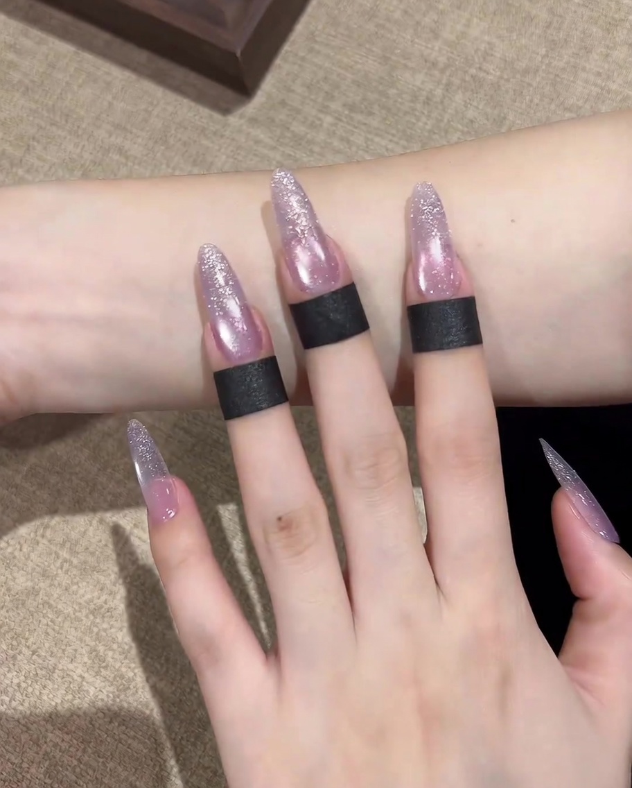 Un primo piano di un pennello che applica uno strato di base gel trasparente su ununghia naturale pulita e preparata.